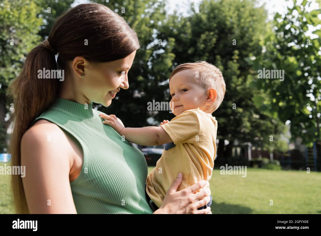 giovane mamma allegra che tiene in braccio felice figlio del toddler Foto Stock