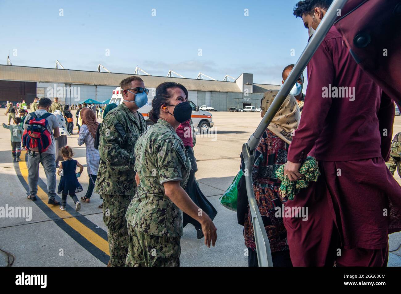 Rota, Spagna. 27 ago 2021. I marinai della Marina degli Stati Uniti assistono i rifugiati afghani evacuati da Kabul all'arrivo alla Stazione Navale di Rota il 27 agosto 2021 a Rota, Spagna. NS Rota fornisce alloggio temporaneo per gli sfollati dall'Afghanistan come parte dell'operazione Allees Refuge. Credit: Planetpix/Alamy Live News Foto Stock