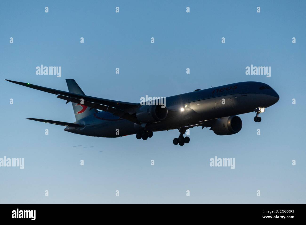 London Heathrow Airport, Londra, Regno Unito. 27 ago 2021. I voli charter continuano ad arrivare a Heathrow dall'aeroporto World Central di Dubai trasportando passeggeri che hanno effettuato il trasferimento dall'aeroporto di Kabul. La compagnia aerea italiana Neos è stata impegnata in rotte di volo fuori dalla regione travagliata verso destinazioni europee con rimpatri in Afghanistan e rifugiati. Il volo ritardato numero NO371, un Boeing 787 Dreamliner, è visto arrivare a Heathrow al crepuscolo Foto Stock