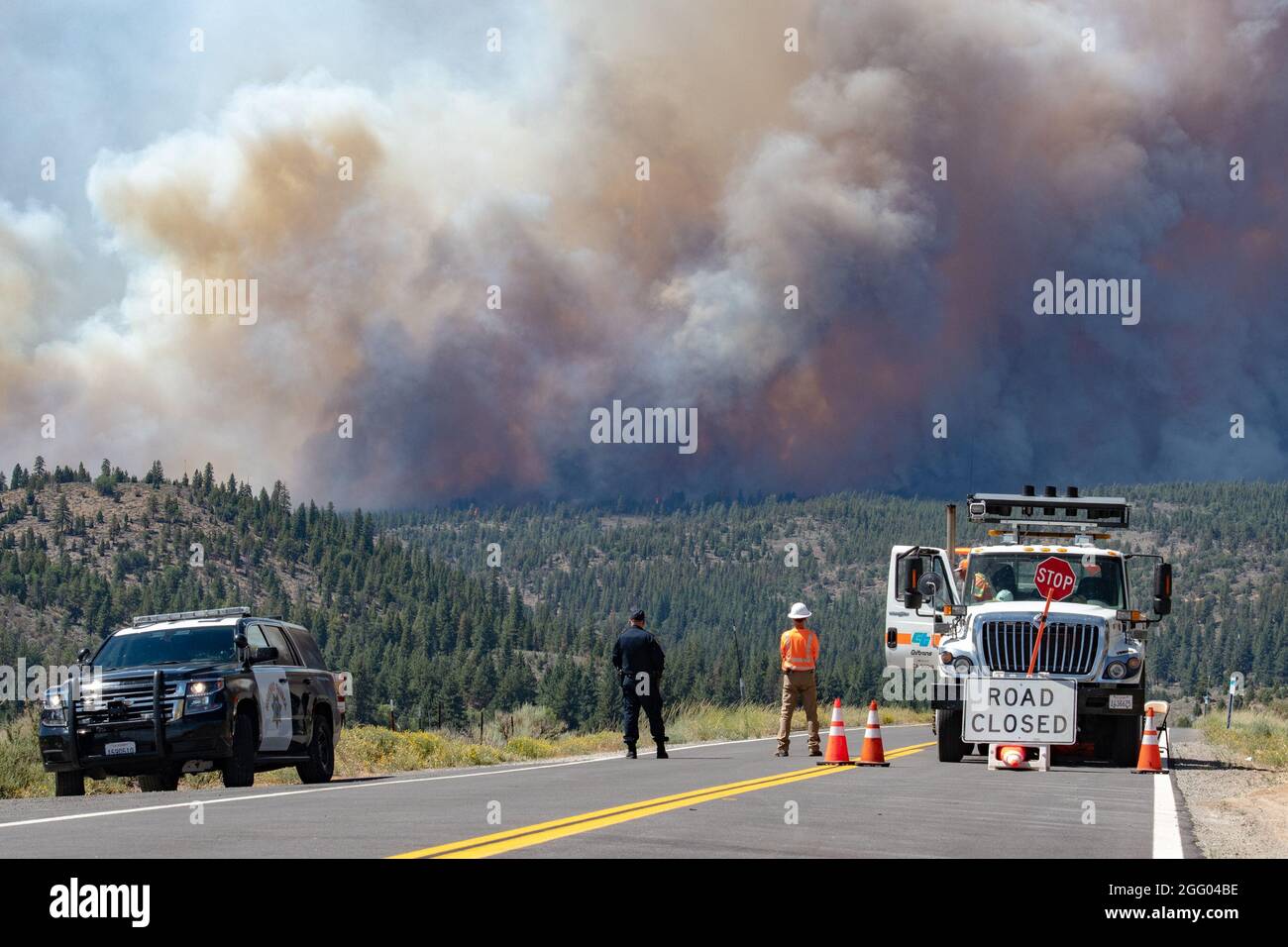 I dipendenti della California Highway Patrolman e della CalTrans guardano il Beckwourth Complex Fire 8 luglio 2021 vicino al lago Frenchman nella California del Nord. Stanno fornendo la chiusura della strada e l'ingresso e l'accesso sicuri per i vigili del fuoco e altre risorse nella zona. Molte risorse sono state attivate per contenere questo incendio, tra cui tre Air National Guard C-130s--due dal Nevada e uno dalla California che aiuterà a combattere il Beckwourth Complex Fire. L'Air Force C-130 MAFFS-equipaggiato aerei, sono richiesti dal National Interagency Fire Center e approvati dal Segretario della Difesa, stanno fornendo Foto Stock