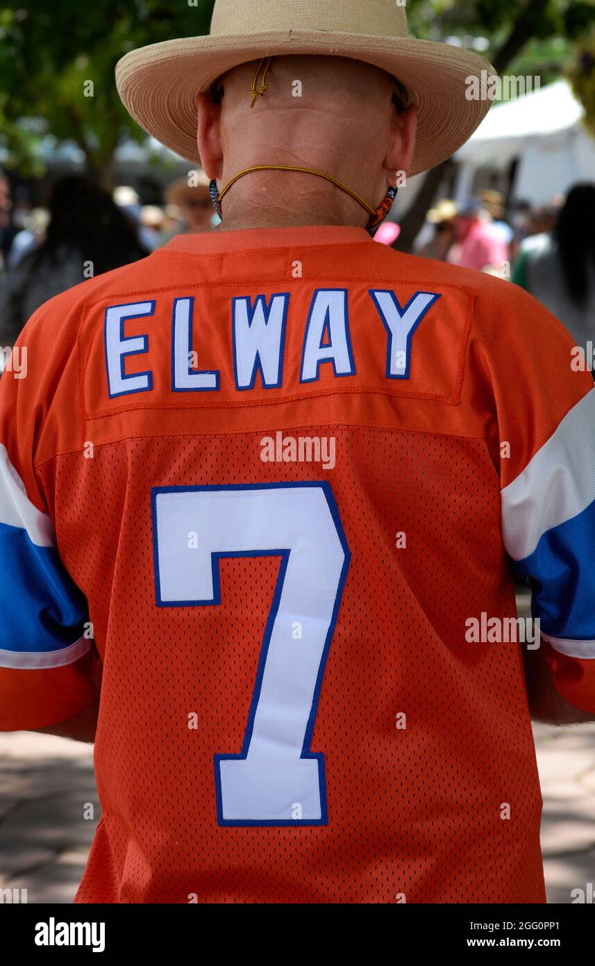Un uomo indossa una maglia da calcio John Elway ricordo. Elway fu un quarto d'indietro per la NFL Denver Broncos dal 1983 al 1998. Foto Stock