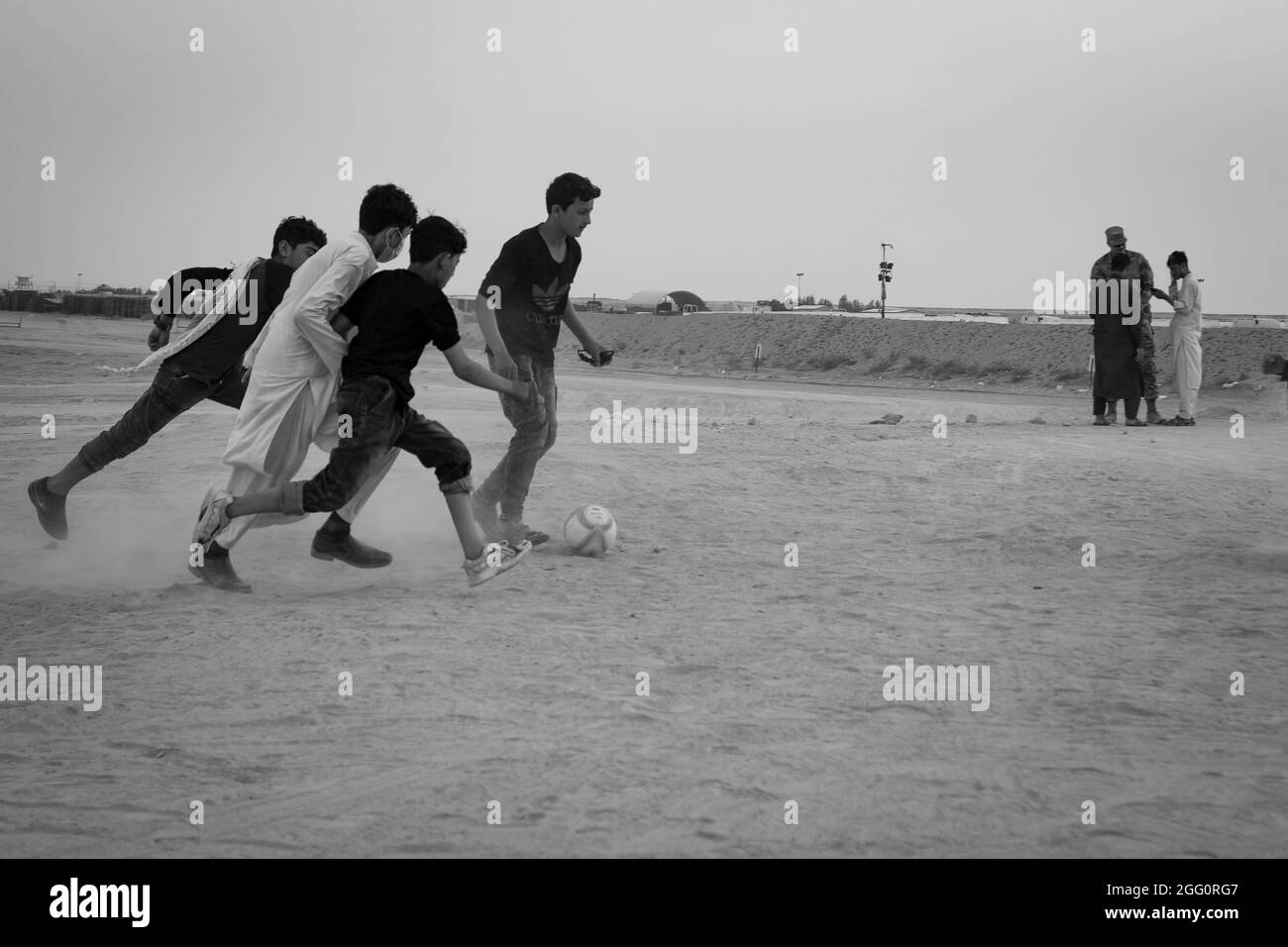 Un gruppo di evacuati afghani gioca una partita di calcio serale a Camp Buehring, Kuwait, 25 agosto 2021. I soldati statunitensi hanno accolto gli sfollati afghani nella struttura a braccia aperte, fornendo una varietà di supporto, per includere attività ricreative e, per facilitare il processo. (STATI UNITI Foto dell'esercito di Sgt. Marc Loi) Foto Stock