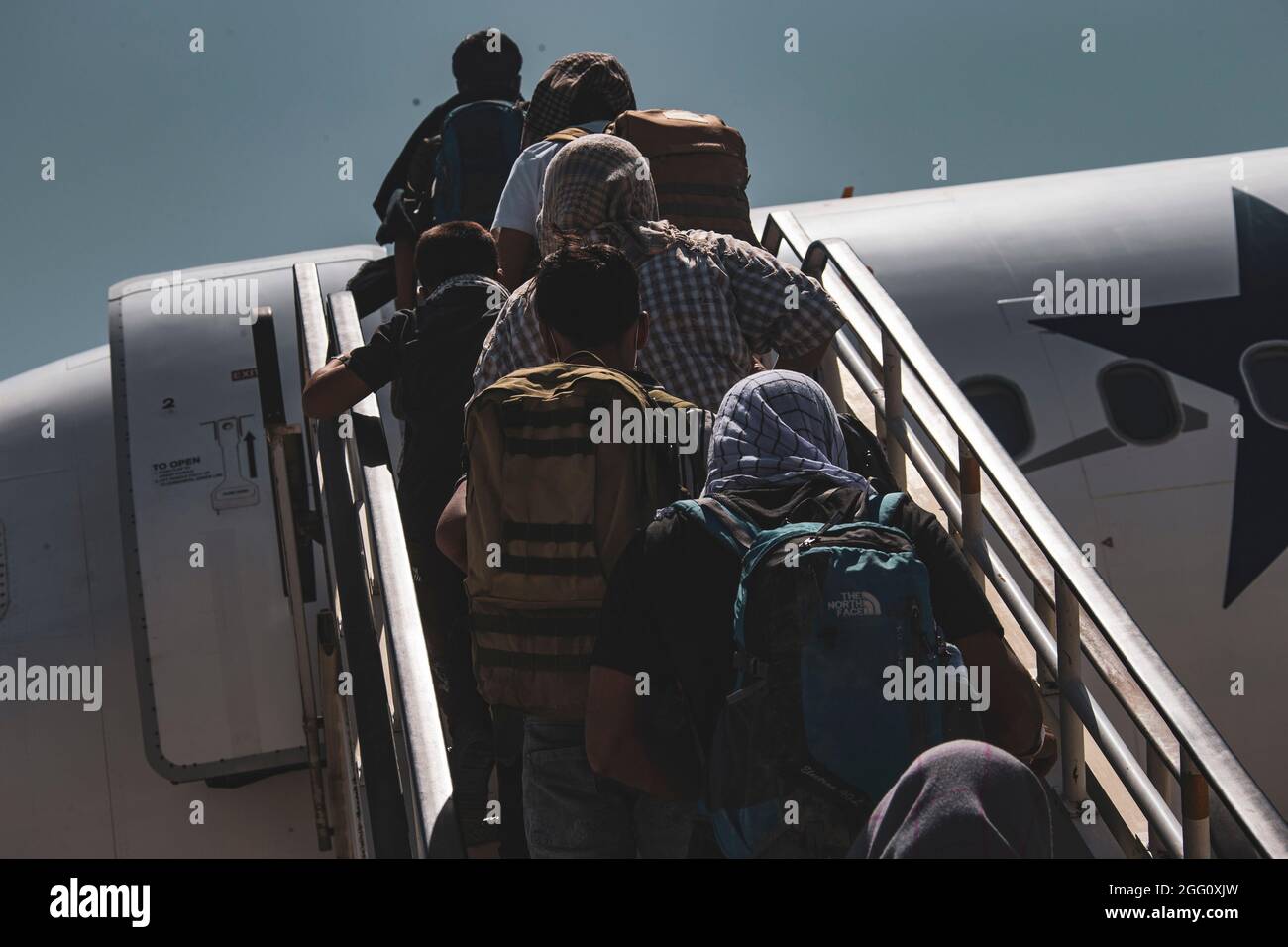 Gli evacuati salpano a bordo di un aereo per l'evacuazione all'Aeroporto Internazionale Hamid Karzai, Afghanistan, 25 agosto. I membri del servizio degli Stati Uniti stanno assistendo il Dipartimento di Stato con un'operazione DI evacuazione non combattente (NEO) in Afghanistan. (STATI UNITI Foto del corpo marino di CPL. Davis Harris) Foto Stock