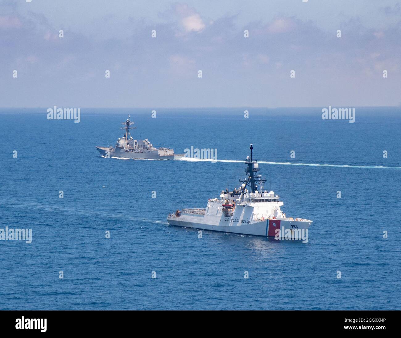 TAIWAN STRAIT (agosto 27, 2021) Cutter Munro (WMSL 755) della Guardia Costiera degli Stati Uniti di classe Legenda transita nello stretto di Taiwan durante un transito di routine con il cacciatorpediniere missilistico guidato di classe Arleigh-burke USS Kidd (DDG 100), agosto 27. Kidd è schierato a sostegno del Commander, Task Force (CTF) 71/Destroyer Squadron (DESRON) 15, il più grande DESRON schierato in avanti della Marina e la principale forza di superficie della flotta statunitense 7. (STATI UNITI Foto Navy di Mass Communication Specialist terza classe Kaylianna Genier) Foto Stock