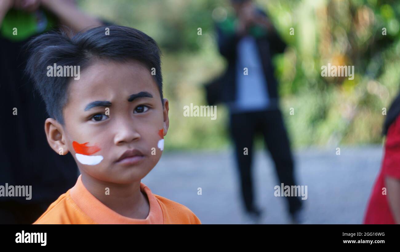 un ragazzo festeggia il giorno dell'indipendenza. Lo sguardo nei suoi occhi mostra la sincerità di una persona che ama veramente la sua patria. Foto Stock