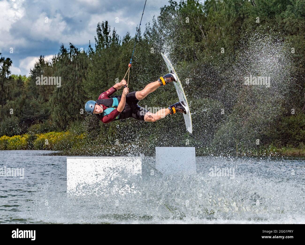 Summertine, sport acquatici, attività e vacanza concetto. Outoor ha girato di irriconoscibile pilota maschile facendo un salto estremo, mostrando il trucco del rullo posteriore lato tacco Foto Stock