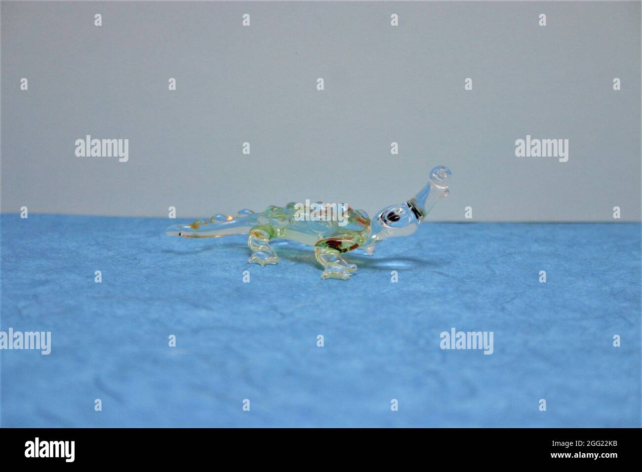 Deko Figur Krokodil trasparente aus Glas auf Blauen Untergrund Foto Stock