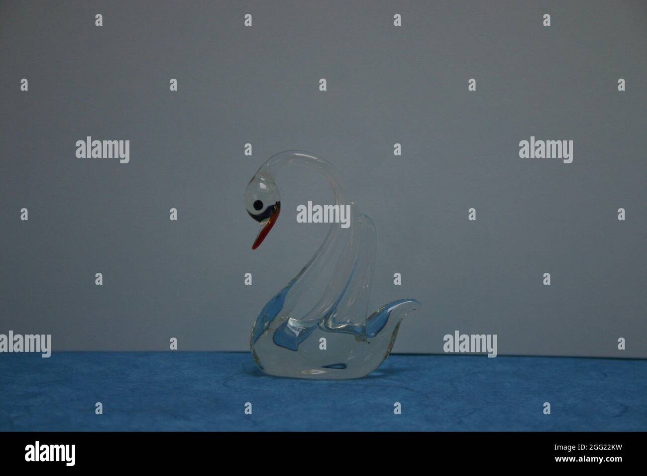 Deko Figur Schwan trasparente aus Glas auf Blauen Untergrund Foto Stock