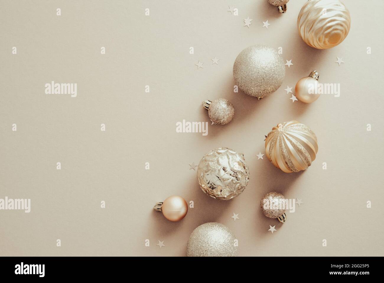 Elegante sfondo natalizio con palle decorative e confetti in beige. Xmas banner design, biglietto d'auguri di Capodanno mockup. Disposizione piatta, vista dall'alto, overh Foto Stock