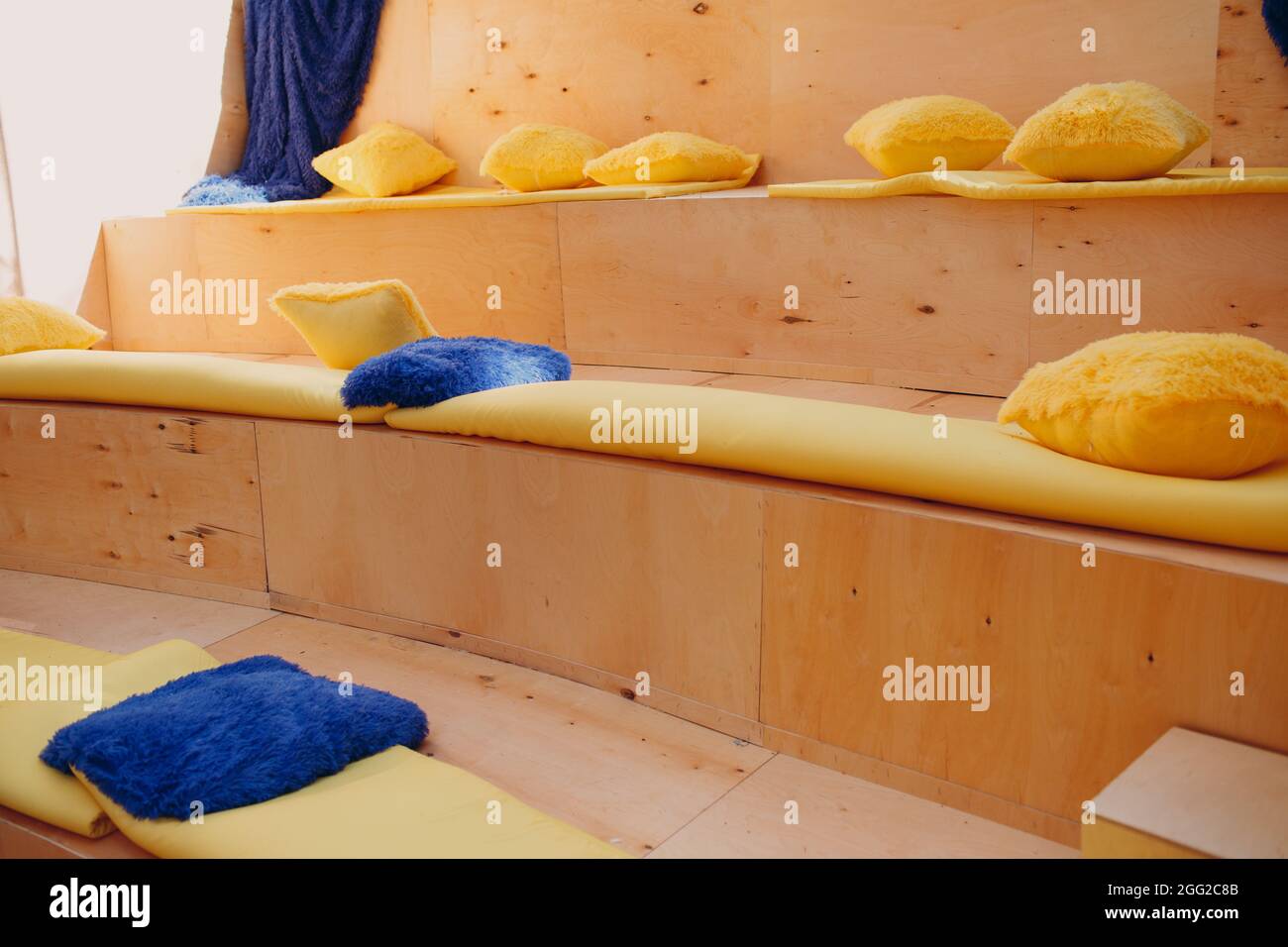 piccolo anfiteatro in legno per spettacoli casalingi con morbidi cuscini multicolore sui sedili. Foto Stock