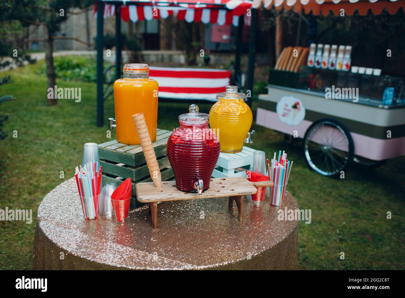 succo di frutti di bosco in grandi bottiglie sul tavolo esterno. Foto Stock