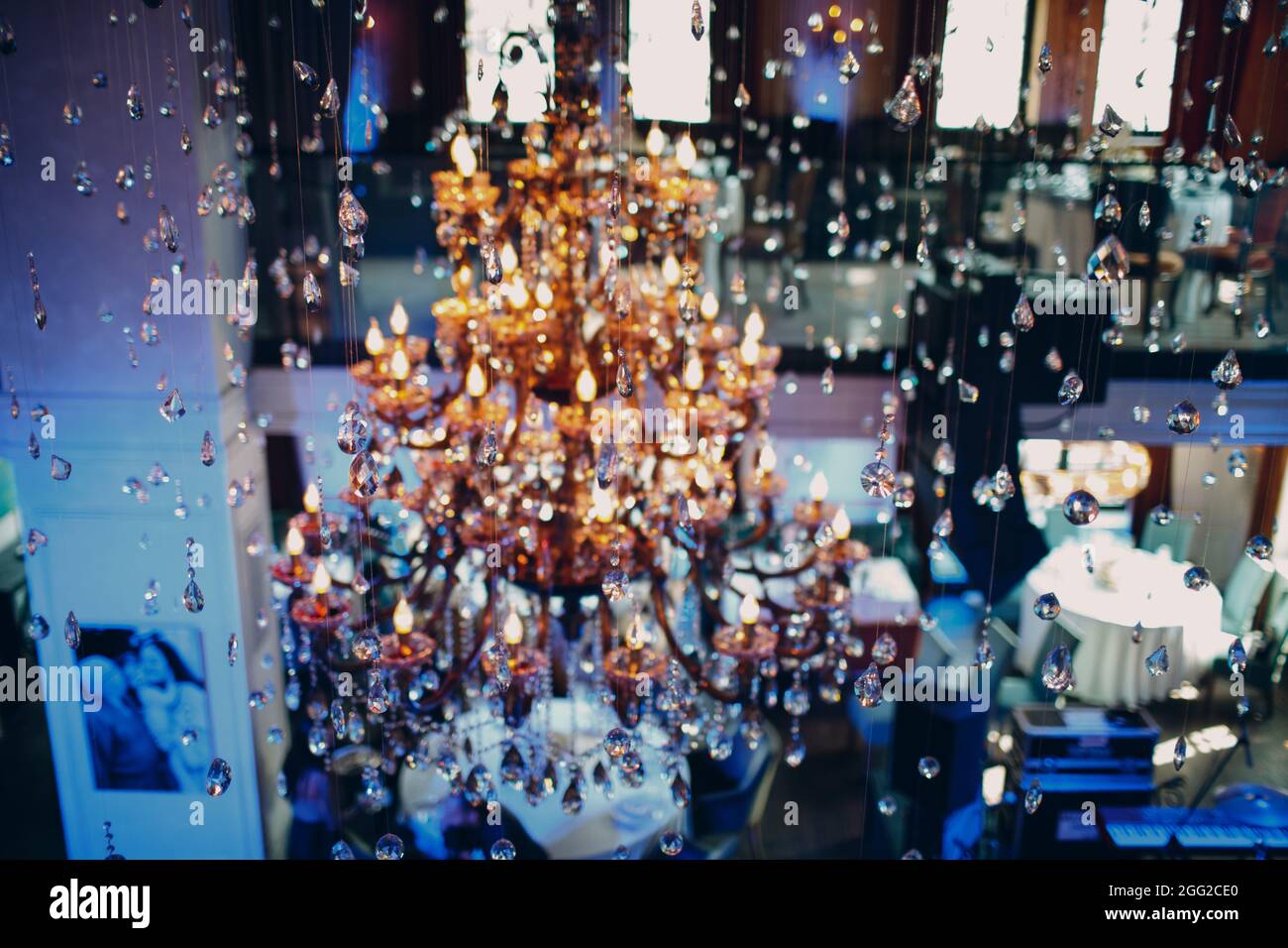grande lampadario di cristallo illuminato con luce multicolore nel ristorante. Foto Stock