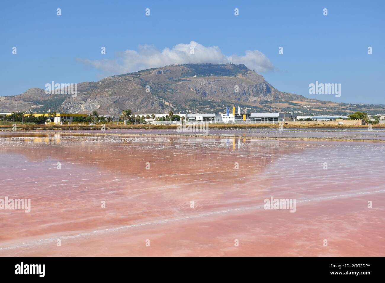 Il Monte Erice si riflette nelle acque rosse delle Saline di Trapani in Sicilia Foto Stock