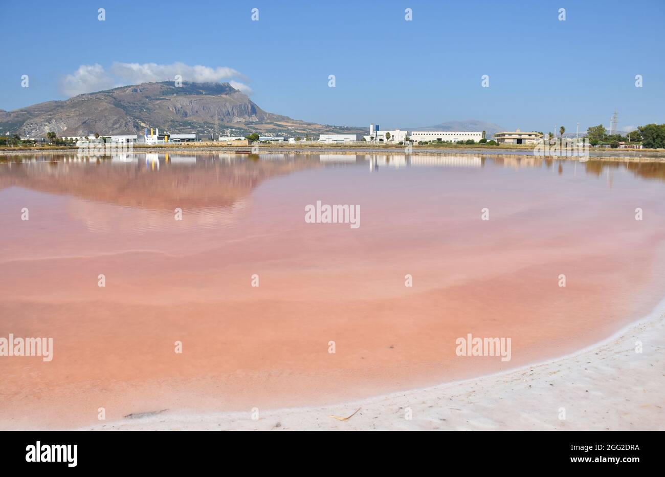 Il Monte Erice si riflette nelle acque rosse delle Saline di Trapani in Sicilia Foto Stock