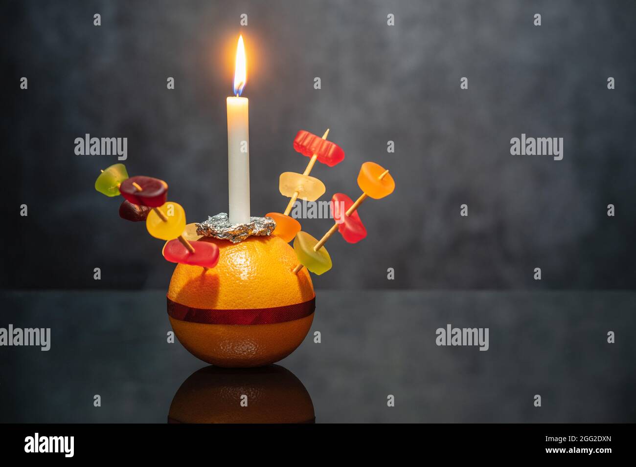 Orange Christingle è un oggetto simbolico utilizzato in Avvento, nel Natale ed Epifania servizi di molte confessioni cristiane Foto Stock