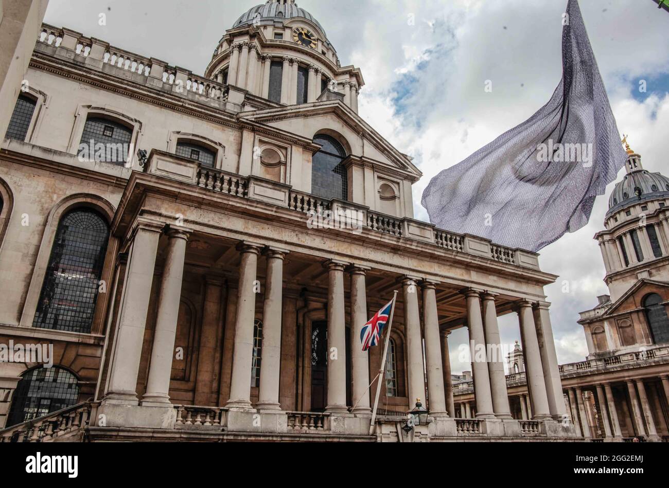 Londra UK 28 agosto 2021 come parte del Greenwich & Docklands International Festival Dan Acher’s We are watching, è un’immagine impressionante di un occhio gigante che sorvolava una bandiera monumentale, composta da migliaia di ritratti digitali, Contributo di persone provenienti da 190 paesi di tutto il mondo.la bandiera di alto livello a 10 piani è stata progettata per inviare un messaggio chiaro ai leader mondiali con il potere di influenzare le decisioni sul cambiamento climatico: Che gli occhi del mondo sono su di loro. Stiamo guardando volerà sopra Greenwich dal 27 al 30 agosto, in anticipo rispetto al COP26 previsto nel corso di quest'anno a Glasgow.Paul Quezada-Neiman/Alamy Foto Stock