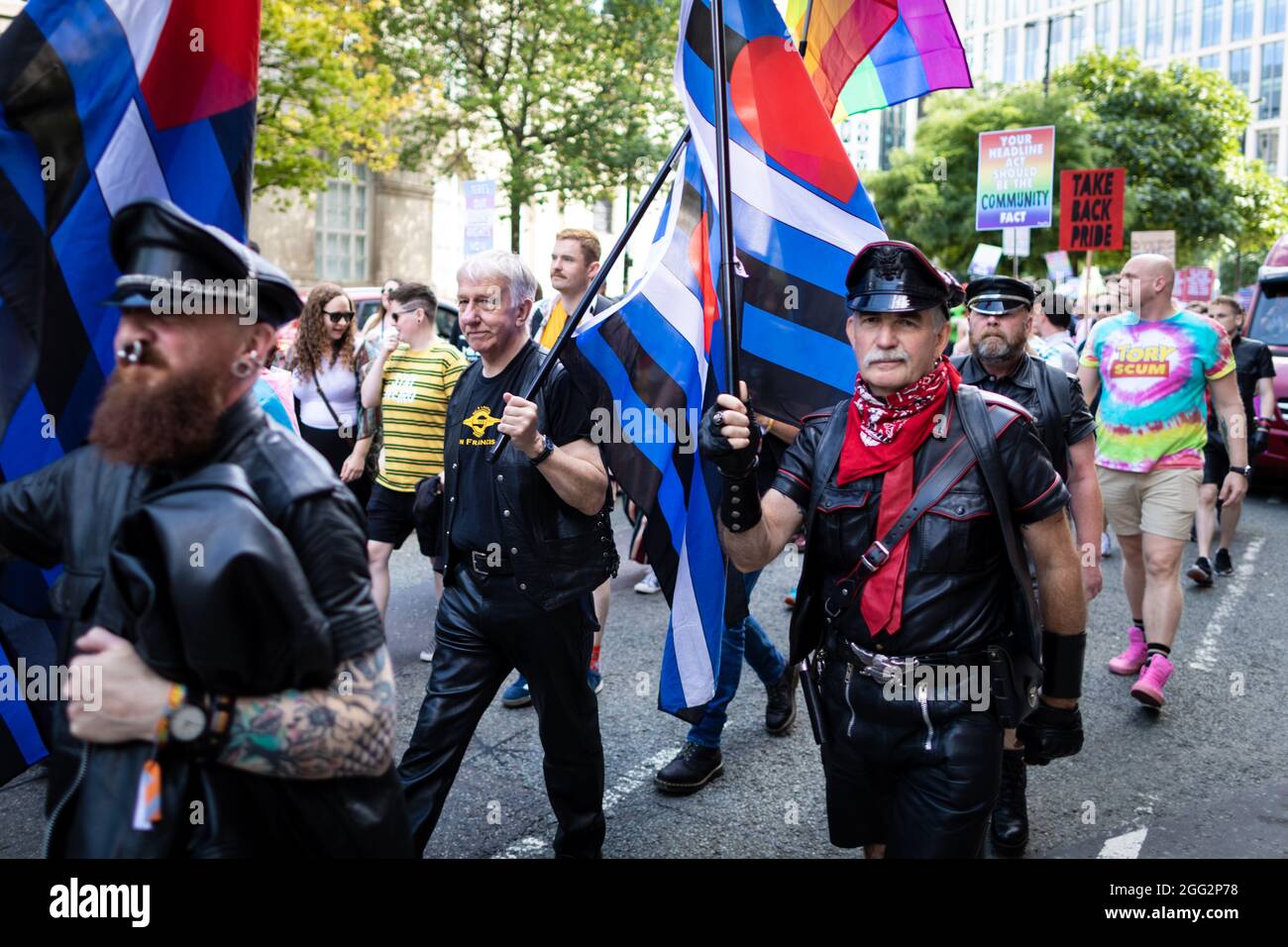 Manchester, Regno Unito. 28 agosto 2021. I manifestanti con bandiere marciano attraverso la città durante una protesta Pride. Centinaia di persone marciano attraverso la città per protestare contro Manchester Pride Ltd. I manifestanti chiedono finanziamenti migliori per le associazioni di beneficenza e i gruppi comunitari LGBTQIA di Manchester. Credit: Andy Barton/Alamy Live News Foto Stock