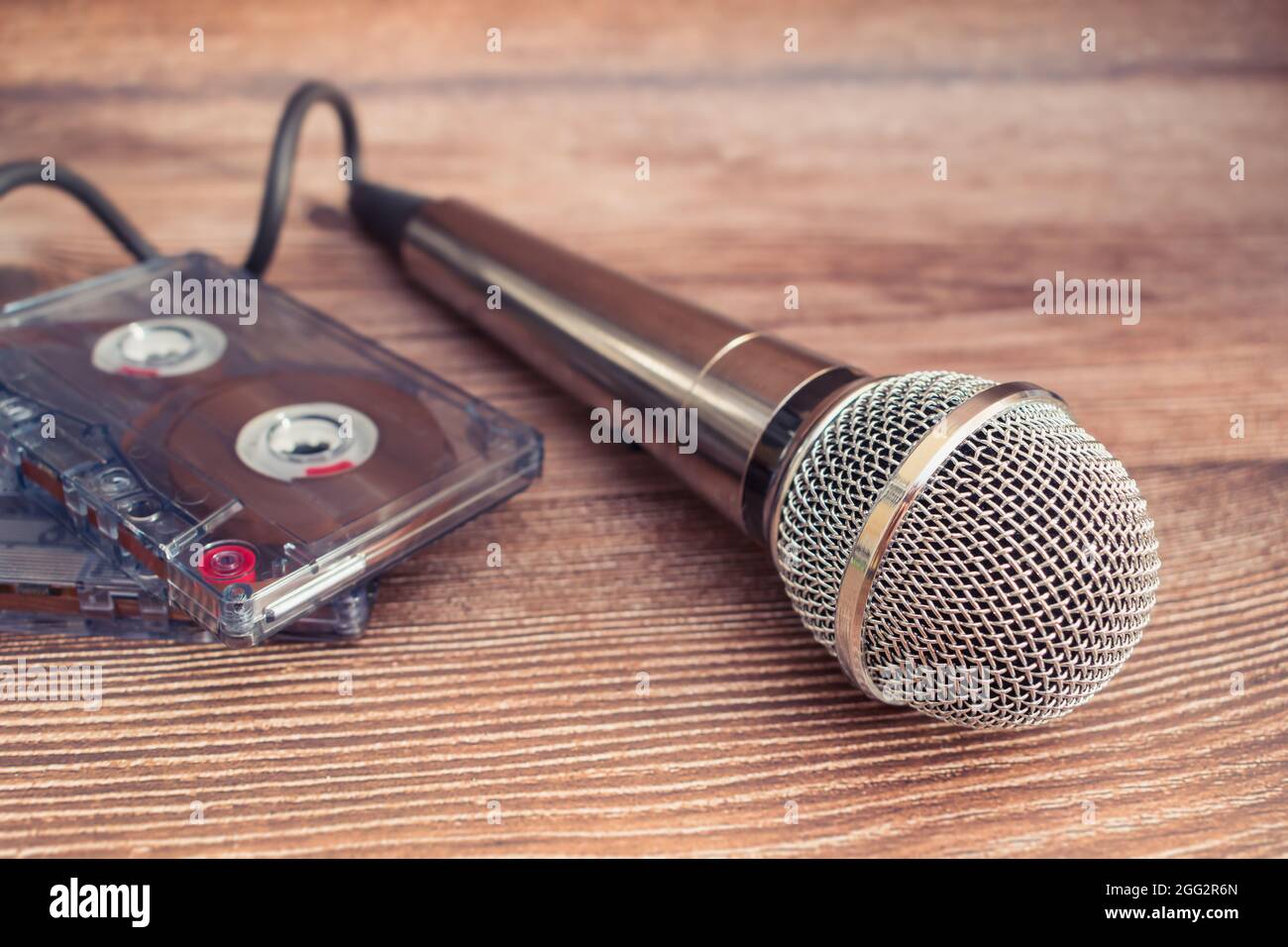 Microfono argento e vecchie cassette audio magnetiche, oggetti di tempi passati Foto Stock