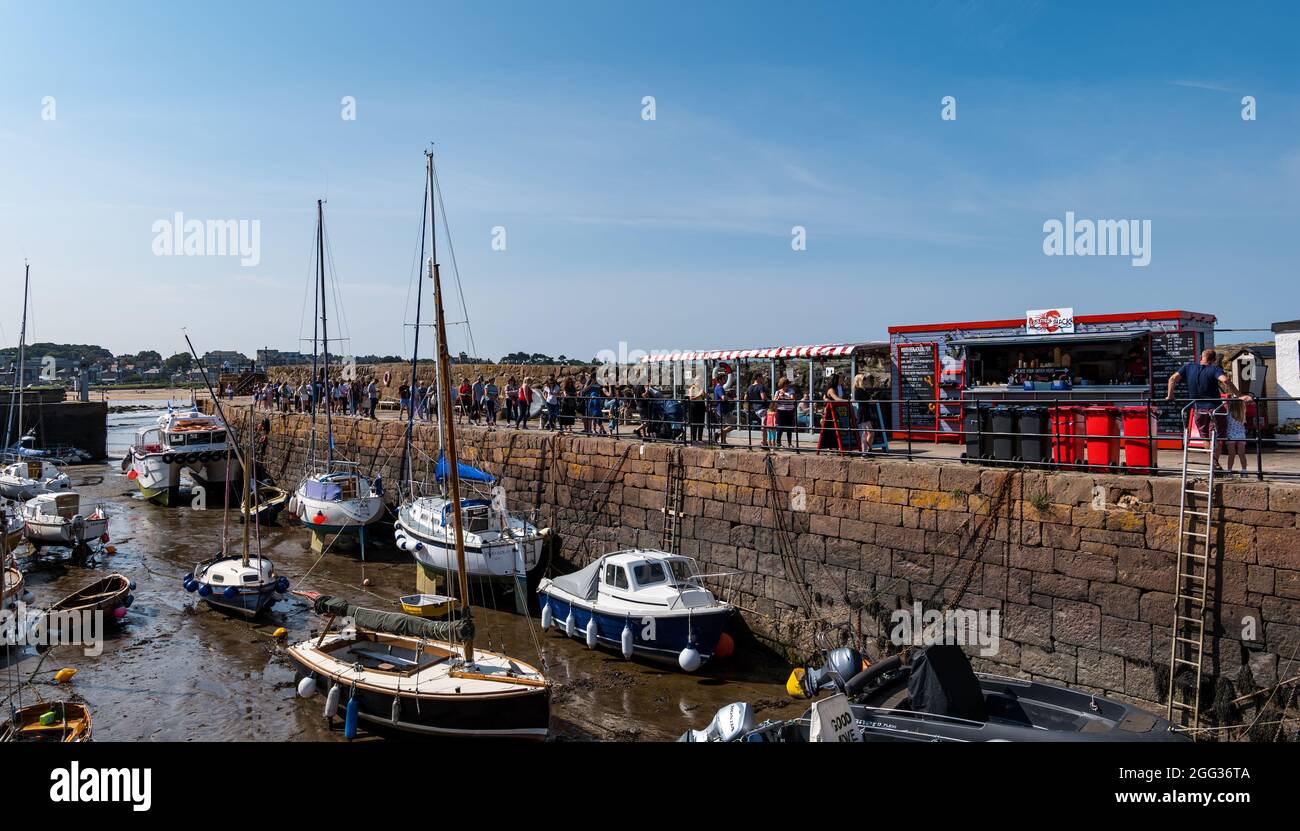 North Berwick, East Lothian, Scozia, Regno Unito, 28 agosto 2021. UK Meteo: La città balneare è piena di persone che si godono il mare e i vari sport acquatici in offerta in un fine settimana di vacanza soleggiato e caldo banca. Nella foto: Una lunga coda si forma per il popolare Lobster Shack decollo nel porto Foto Stock