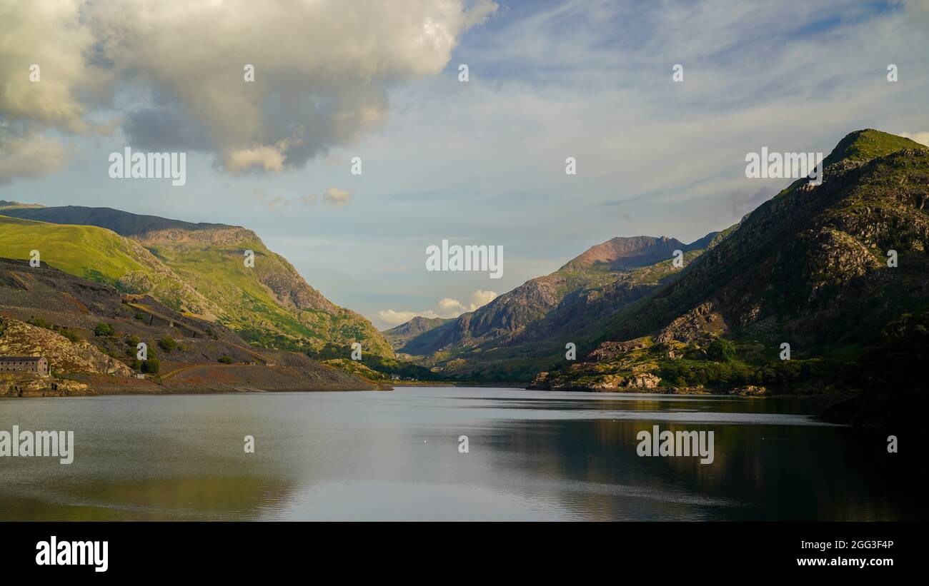 UNA VISTA SUL LAGO ARTIFICIALE DI LLYN PERIS A LLANBERIS, ALL'OMBRA DEL MONTE SNOWDON, IN UN POMERIGGIO SERENO E SOLEGGIATO Foto Stock