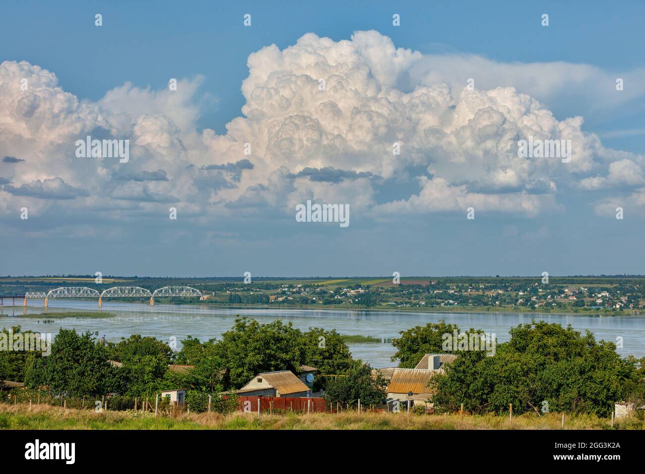 Fiume Bug meridionale e paesaggio rurale estivo, vista del villaggio, ampio fiume, ponte e maestoso cielo nuvoloso, Ucraina. Foto Stock