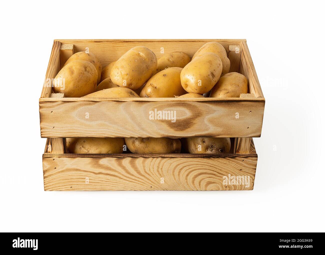 Tuberi crudi di patate in una cassa di legno isolato su sfondo bianco. Patate gialle fresche in una scatola di legno. Contenitore rustico per verdure. Foto Stock