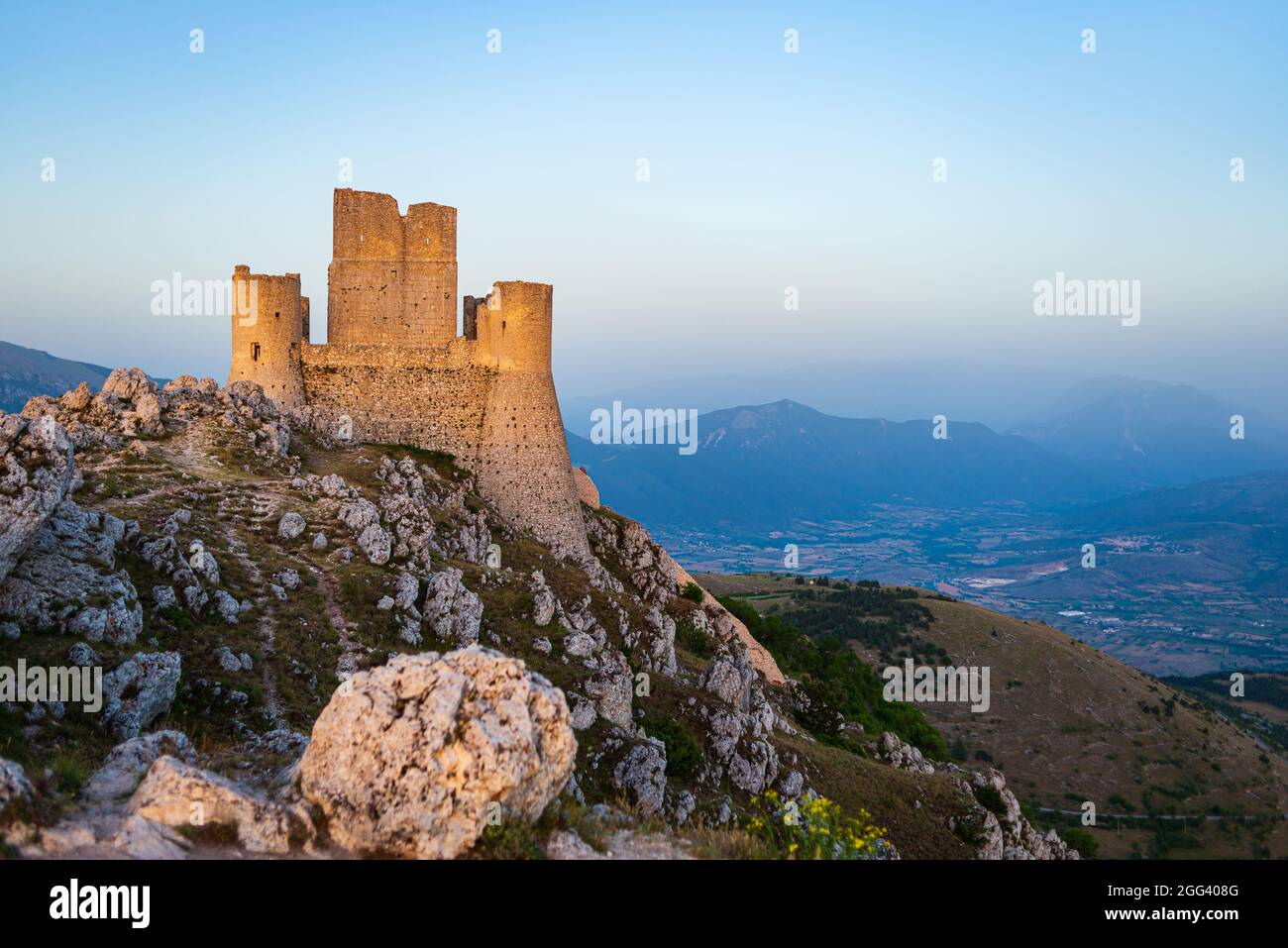 Rovine del castello sulla cima della montagna a Rocca Calascio, meta di viaggio italiana, punto di riferimento nel Parco Nazionale del Gran Sasso, Abruzzo, Italia. Cielo blu chiaro a Foto Stock