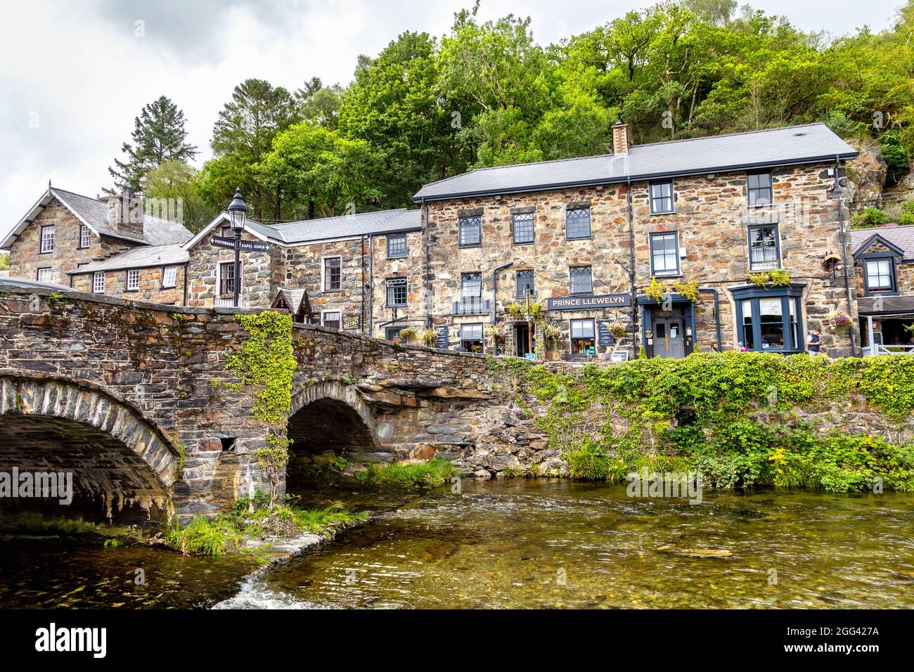 Bridge over the River Colwyn e Prince Llewelyn pub presso Beddgelert villaggio a Gwynedd, Snowdonia National Park, Galles, Regno Unito Foto Stock