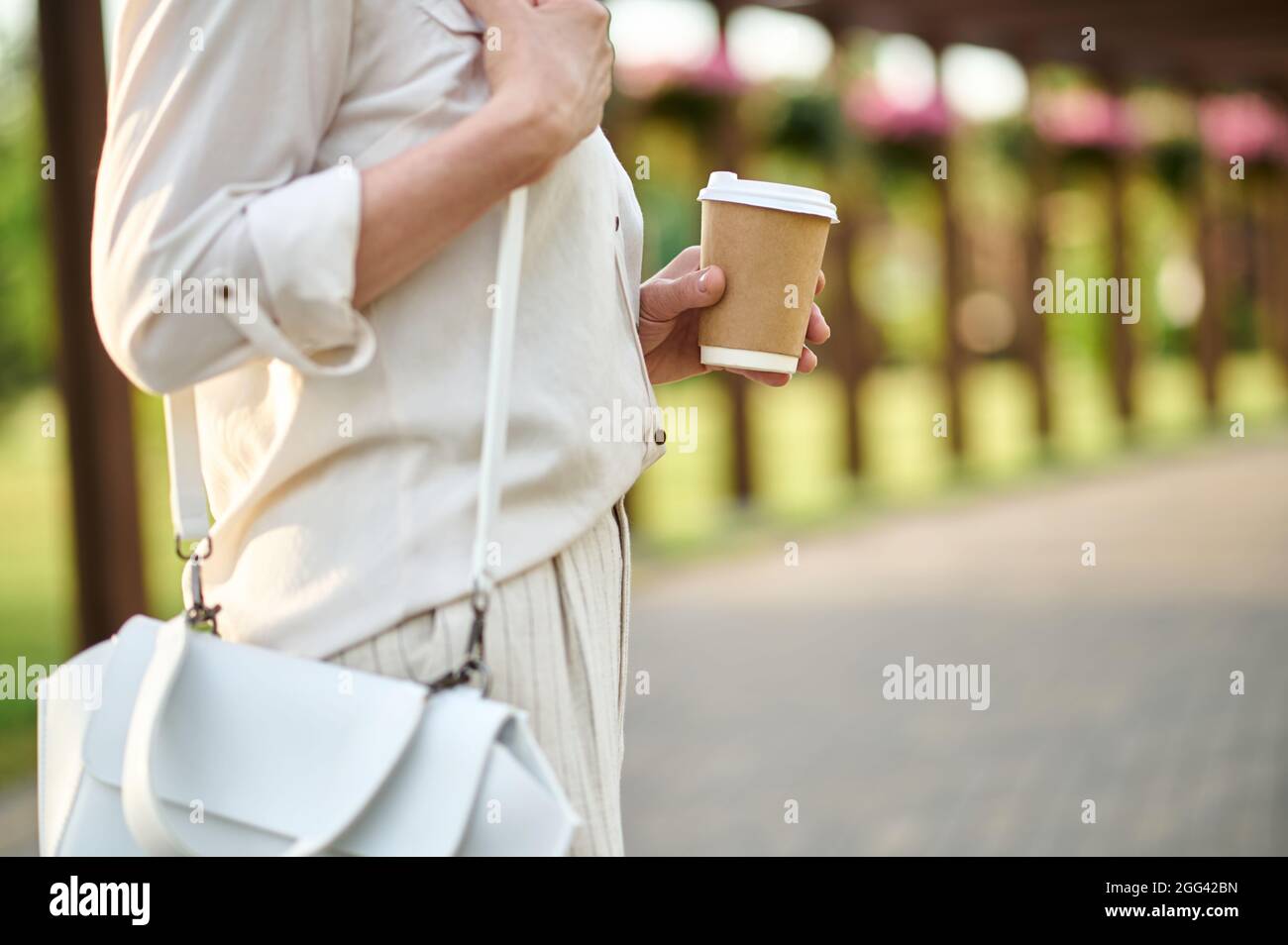 Donna in abiti leggeri con un bicchiere di caffè. Foto Stock