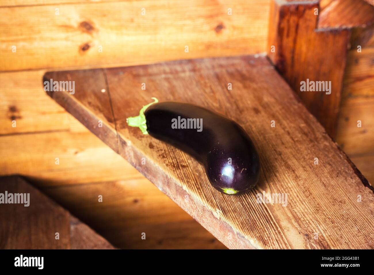 La melanzana si trova su un asse di legno. Vegetale. Foto Stock