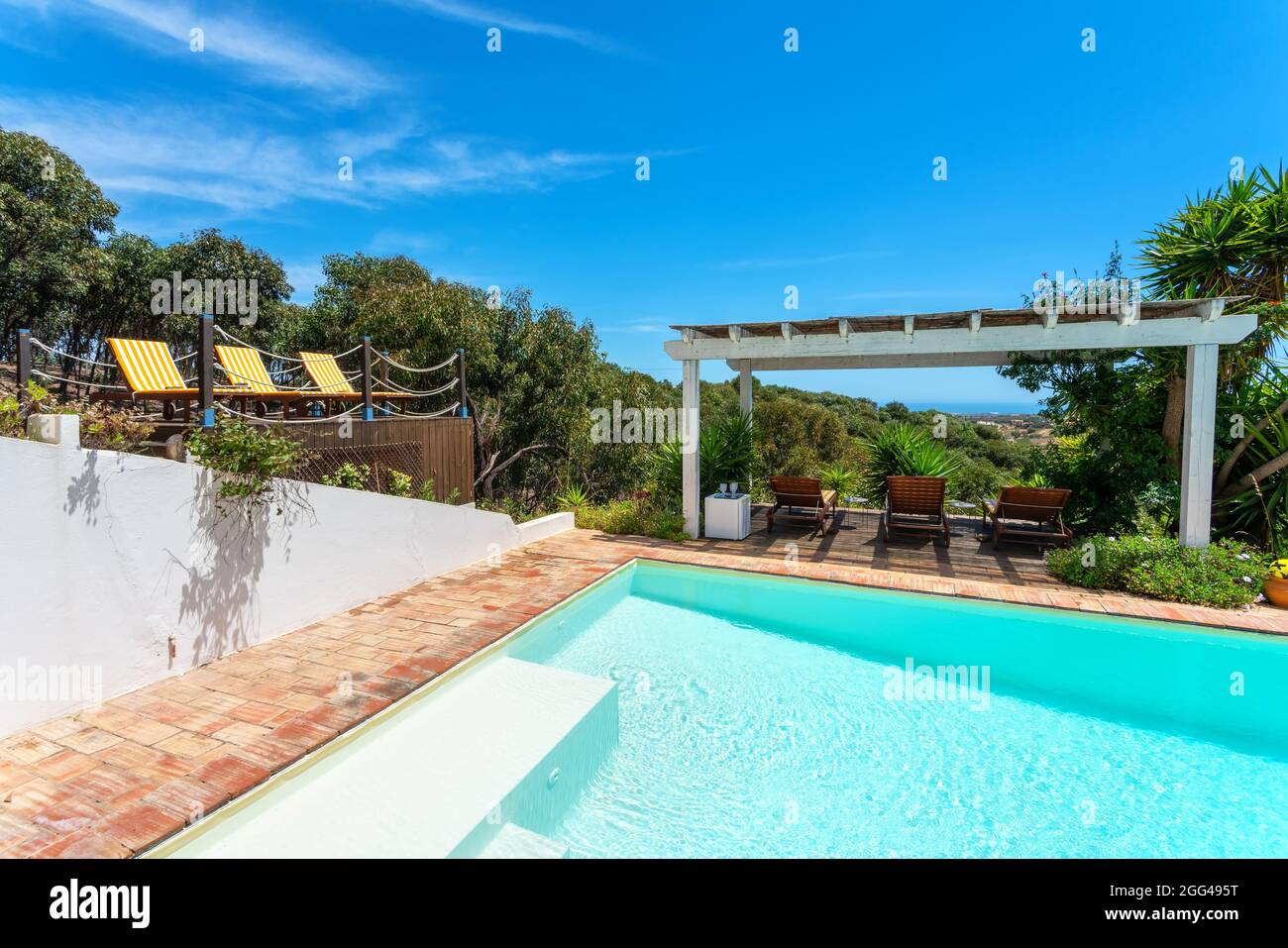 Gazebo nel giardino vicino alla piscina con vista sulla pineta, un luogo  per il relax dei turisti. Lettini per prendere il sole Foto stock - Alamy