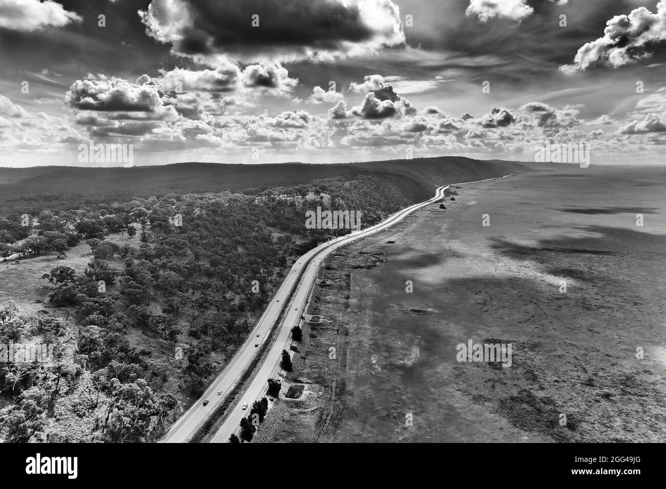 Sydney Canberra autostrada federale lungo il lago George in un clima arido del NSW, Australia - vista panoramica aerea in bianco e nero. Foto Stock