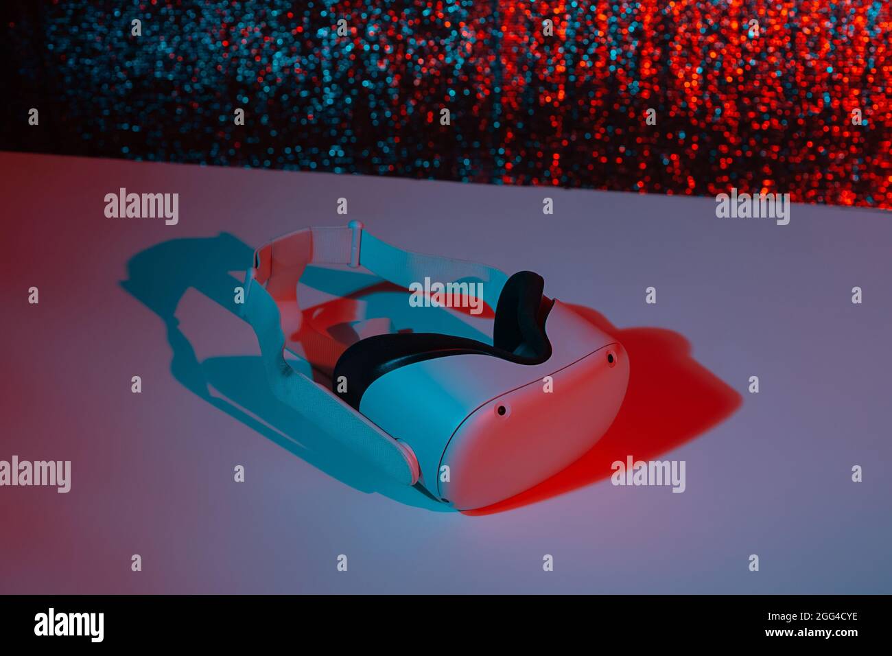 Casco per realtà virtuale su sfondo bianco con luce al neon. Realtà virtuale, futuro, gadget, concetto di tecnologia. Foto Stock