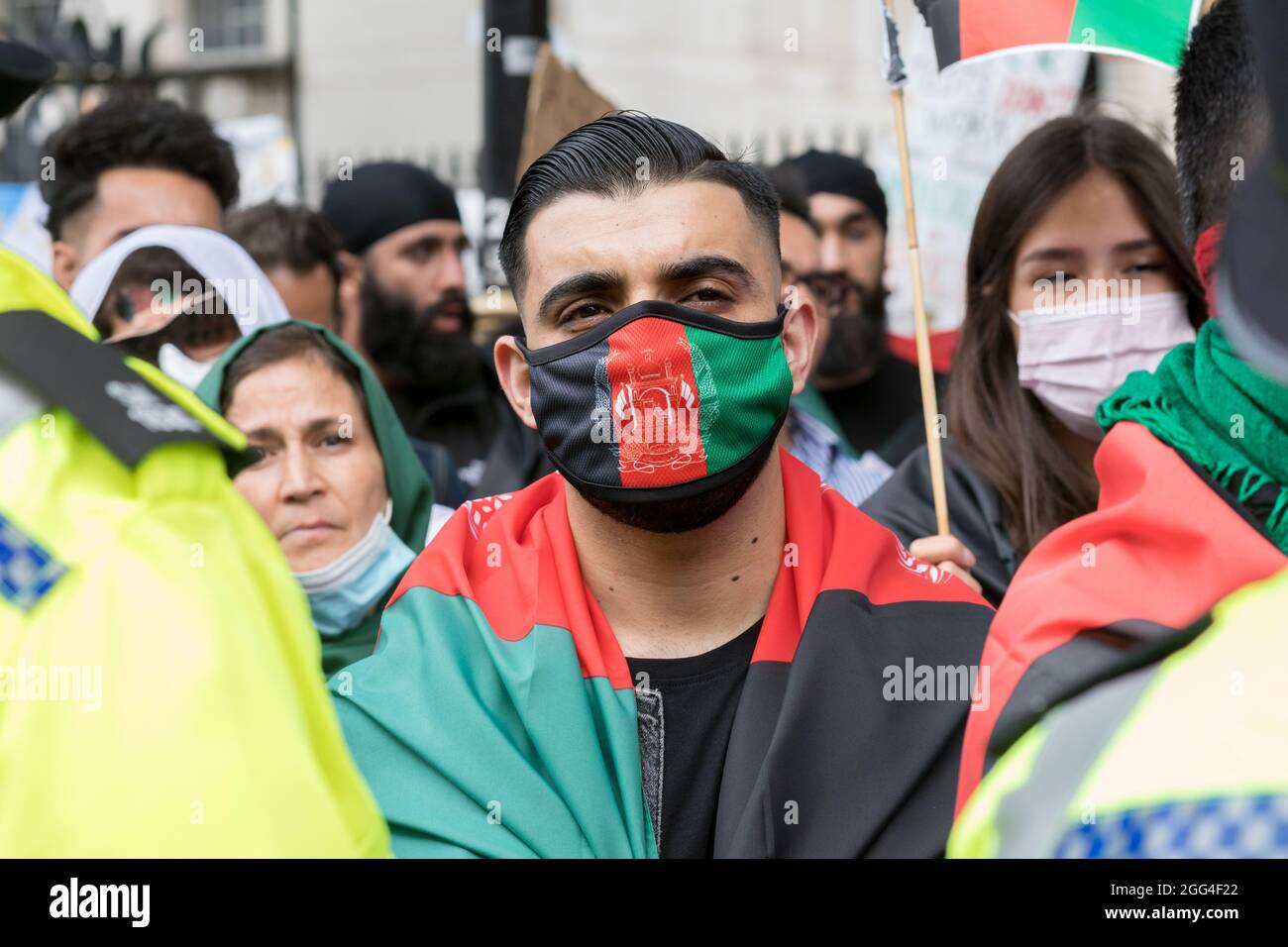 Londra, Regno Unito. 28 agosto 2021. Un uomo afghano che indossa una maschera con la bandiera afghana durante la manifestazione a Westminster. Gli afghani si sono radunati a Londra, organizzata dal Watan, per condannare gli atti di terrorismo dei talebani in Afghanistan. Il Watan come organizzazione che sensibilizza l'opinione pubblica sull'attuale crisi umanitaria in Afghanistan e cerca di unire le forze straniere per ripristinare la pace nel paese. Essi chiedono che le guerre per procura vengano arrestate ora in Afghanistan. Credit: SOPA Images Limited/Alamy Live News Foto Stock