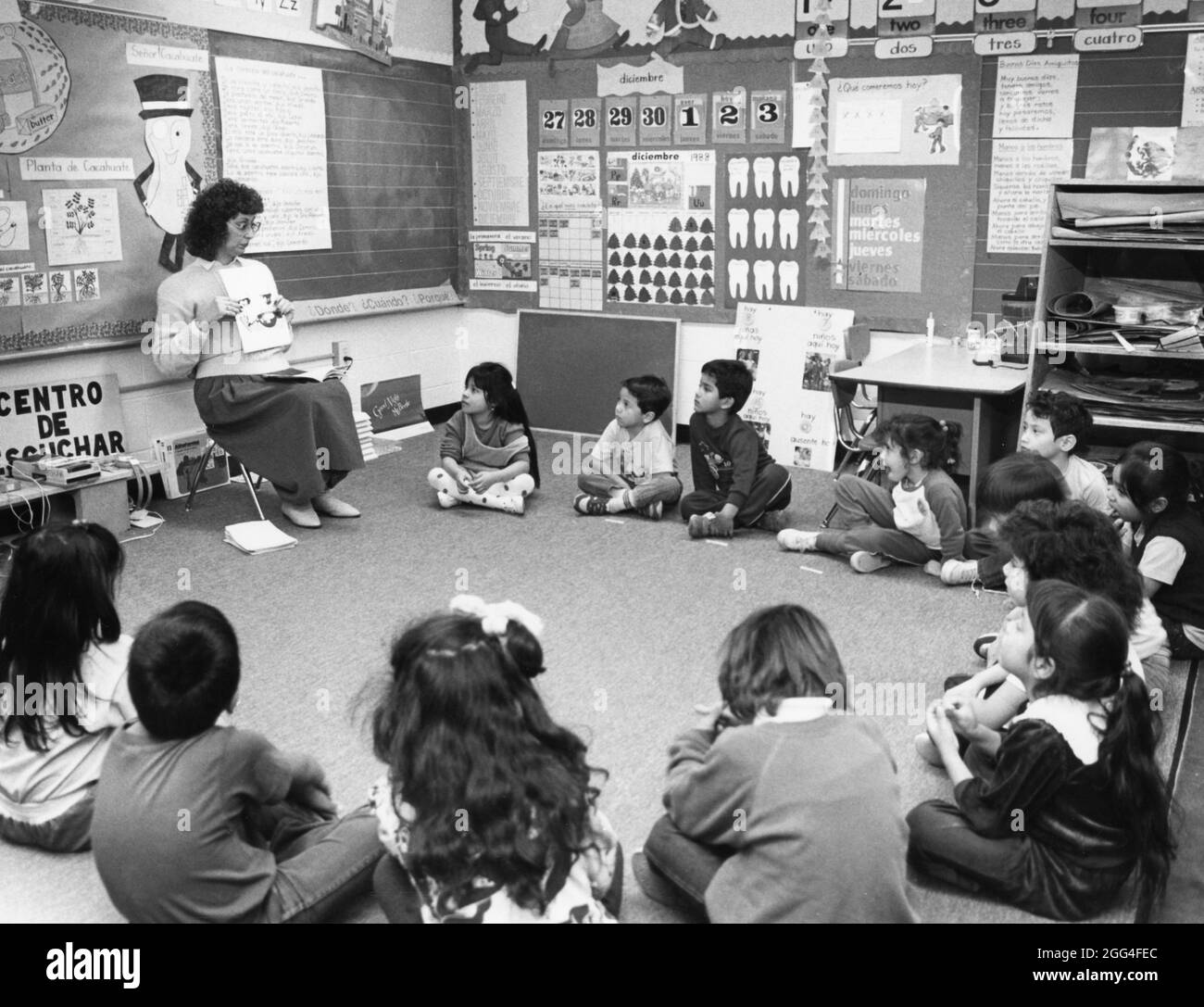Austin Texas USA, circa 1990: L'insegnante di scuola materna ispanica legge agli studenti in inglese e spagnolo durante il periodo di cerchio alla Metz Elementary School. SIG. Es-0453 ©Bob Daemmrich Foto Stock