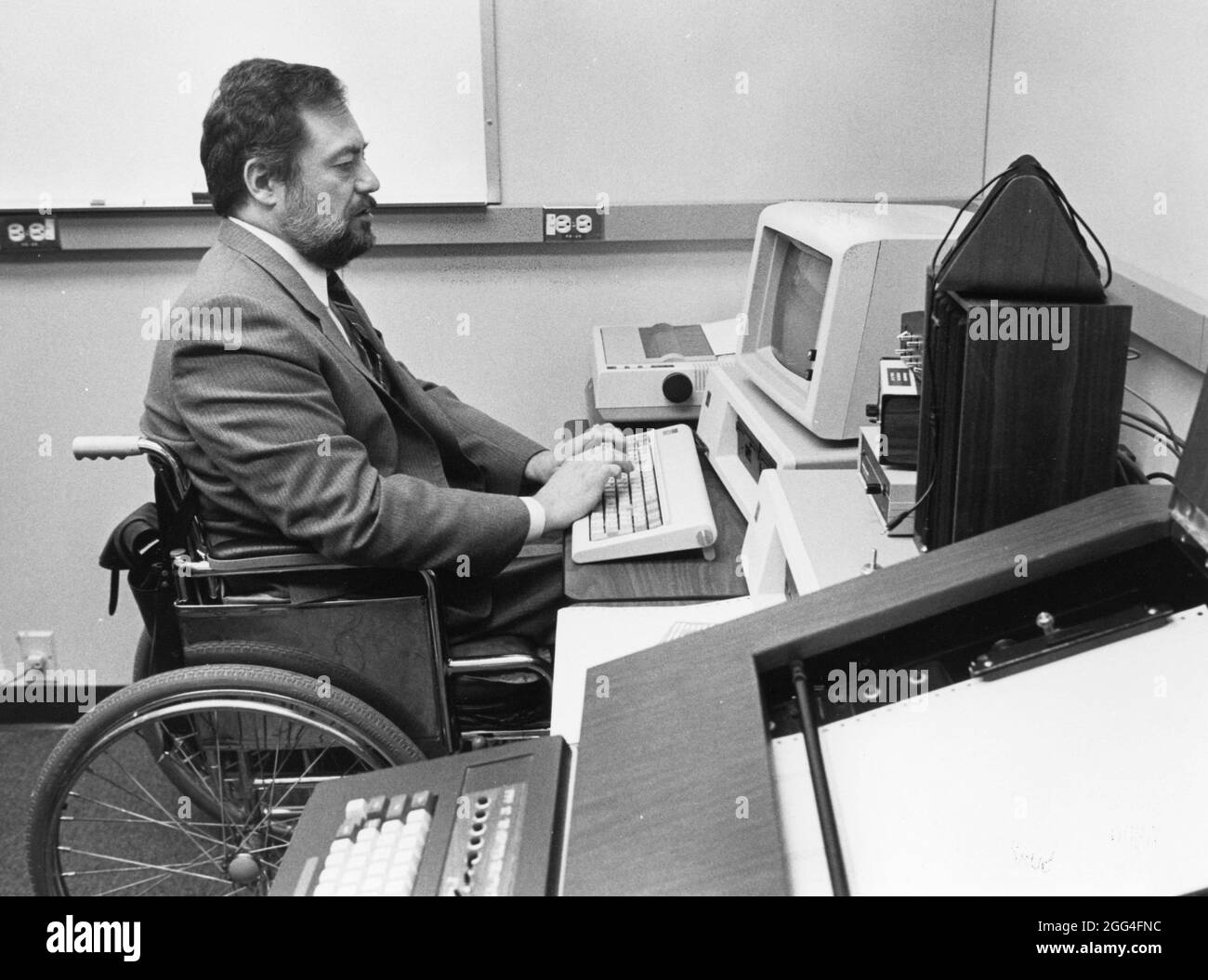 Austin Texas USA, circa 1990: Programmatore informatico IBM legalmente  cieco in sedia a rotelle lavora al computer nel suo ufficio. ©Bob Daemmrich  Foto stock - Alamy