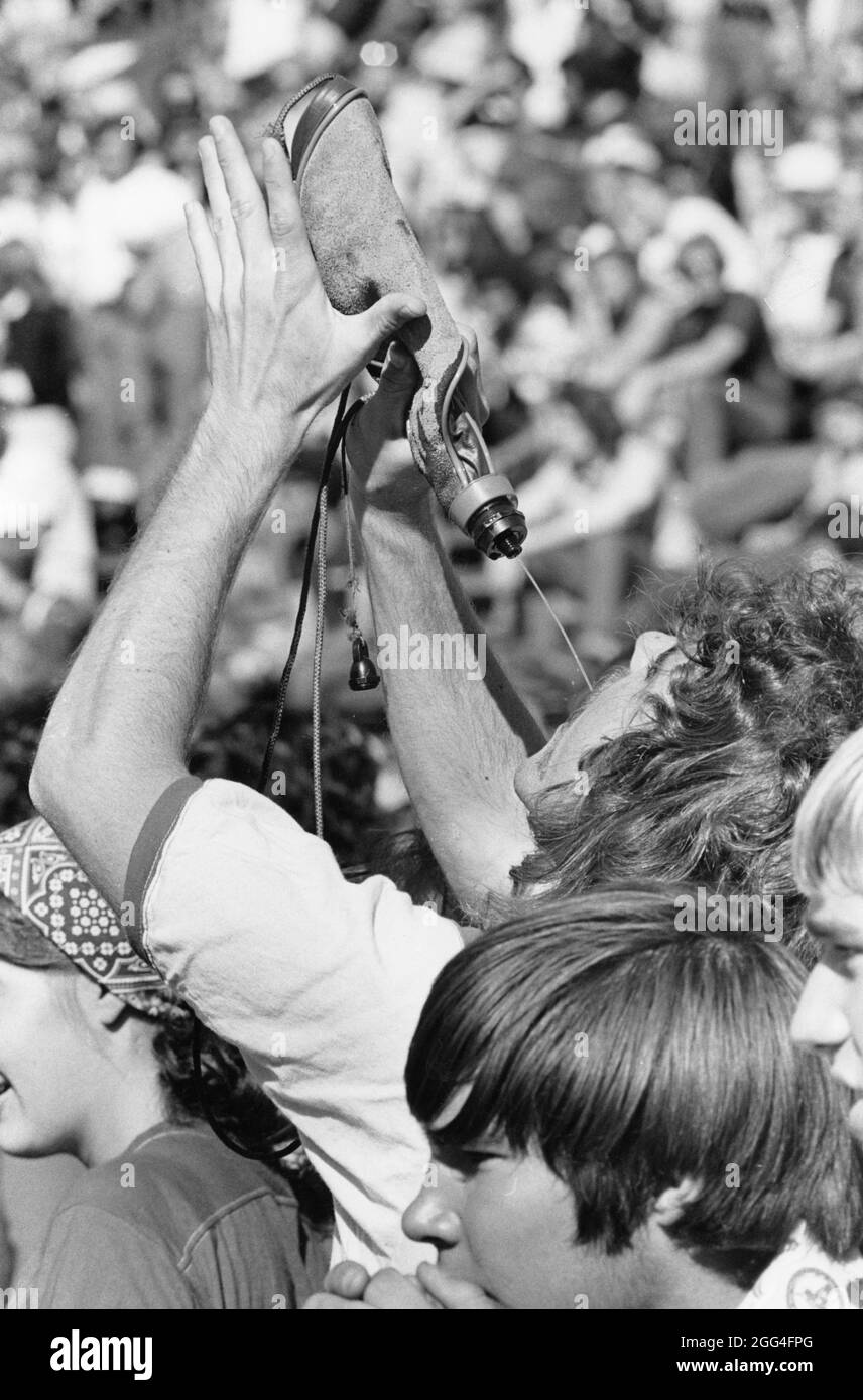 Austin Texas USA, circa 1988: Uomo che beve da una fiasca in una partita di calcio del college. ©Bob Daemmrich Foto Stock