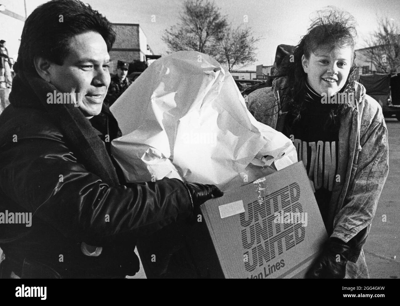 Austin Texas USA, 1990: Adulti e adolescenti volontari consegnano giocattoli e cibo a famiglie a basso reddito poco prima di Natale attraverso il programma Blue Babbo Natale. ©Bob Daemmrich Foto Stock