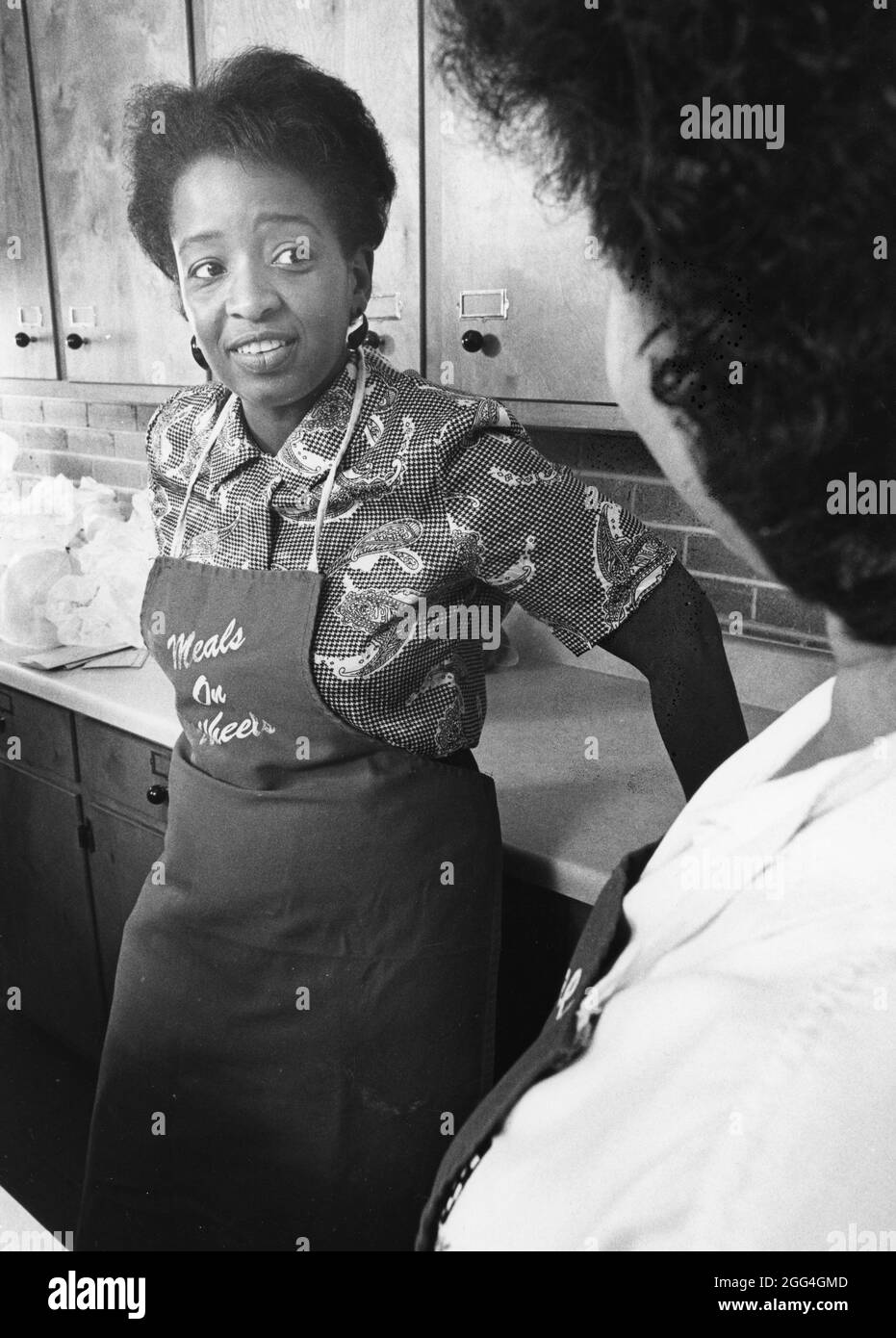 Austin, Texas USA, circa 1989: Pasti su ruote volontario Jessica Fowler impacchi alimenti preparati per la sua consegna a casa basso-reddito Austin re Foto Stock