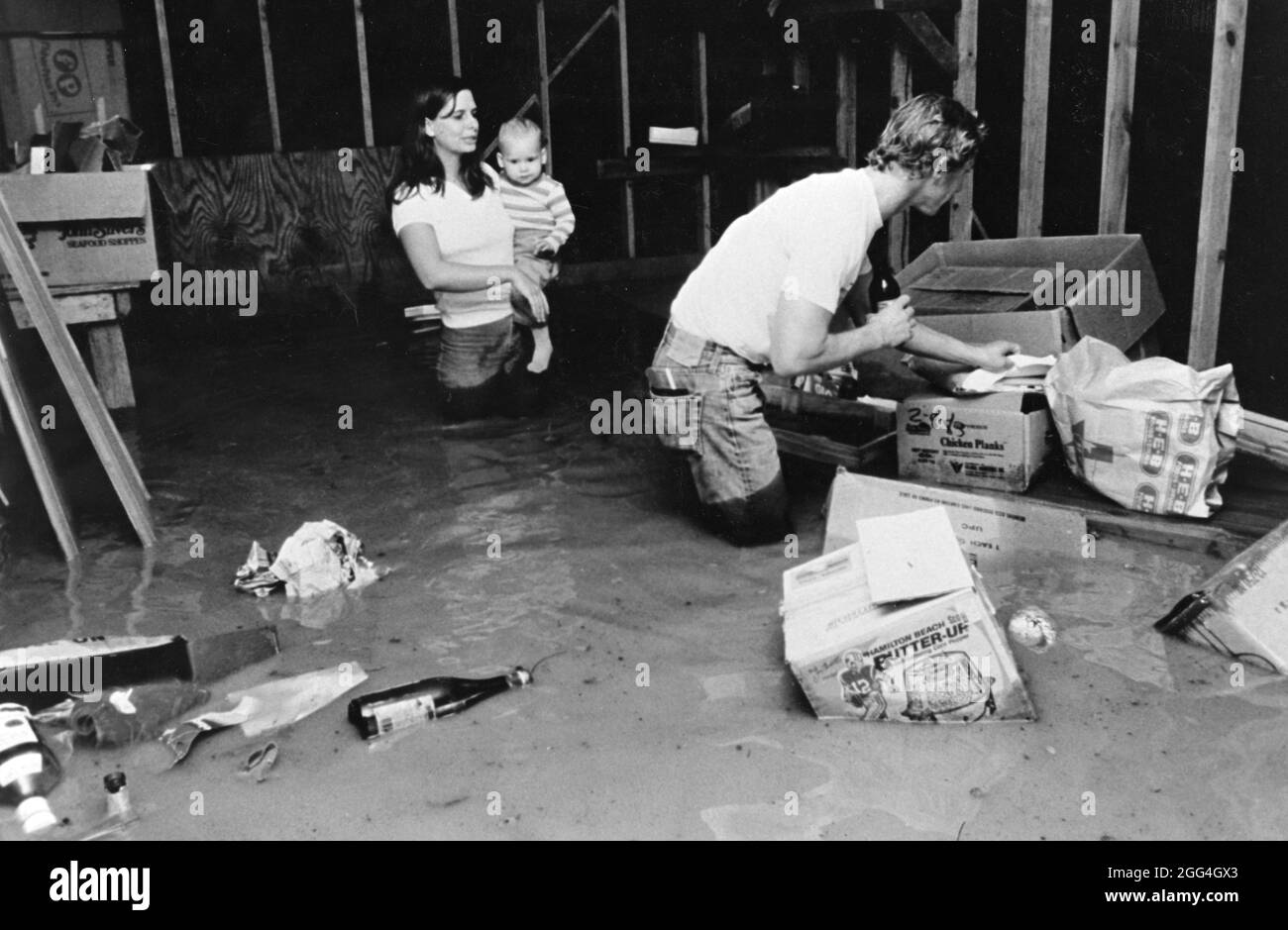 Austin Texas USA, circa 1982: I residenti guardano i loro effetti personali che fluttuano in acque profonde della coscia nel garage della loro casa durante le inondazioni improvvise nel loro quartiere. ©Bob Daemmrich Foto Stock
