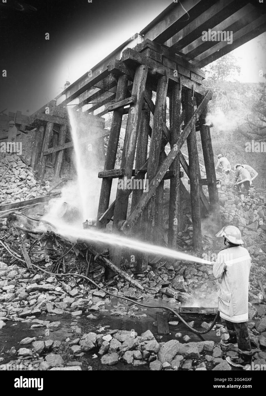 Intorno al 1984, i vigili del fuoco versano l'acqua sotto il ponte dei cavalletti. ©Bob Daemmrich Foto Stock