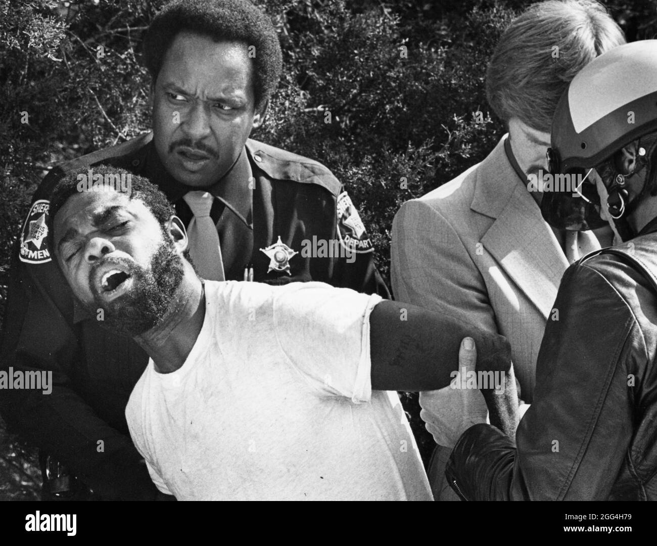 Austin Texas USA, circa 1988: Il vice dello sceriffo nero arresta Black man con l'accusa di tentato omicidio. ©Bob Daemmrich Foto Stock