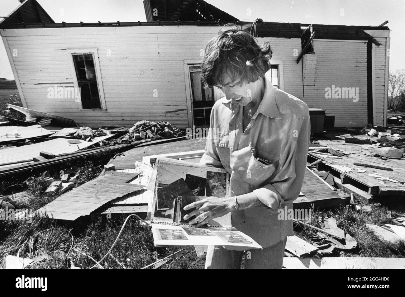 Williamson County Texas USA, 1987: Woman guarda attraverso un album fotografico salvato dalla sua casa danneggiata dal tornado vicino ad Austin. ©Bob Daemmrich Foto Stock