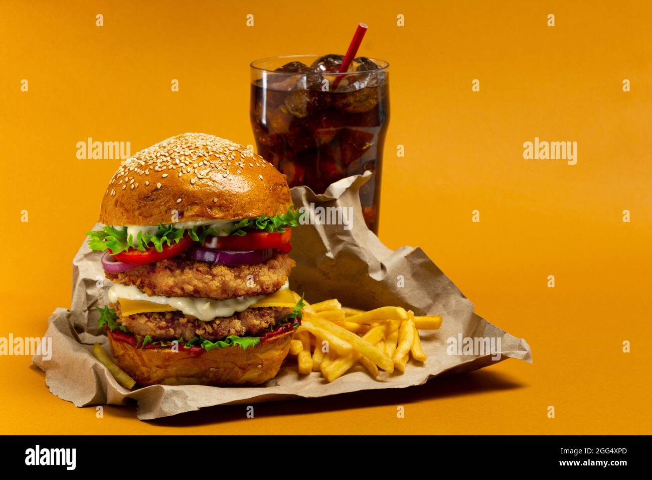 Hamburger di pollo con cola e patatine fritte su sfondo arancione Foto Stock