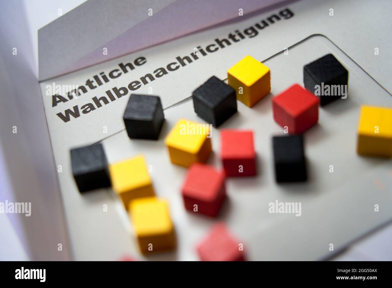 Lettere nere su busta bianca: Notifica ufficiale delle elezioni (in tedesco: Amtliche Wahlbenachrichtigung). Cubi di legno in oro rosso nero. 2021 f Foto Stock