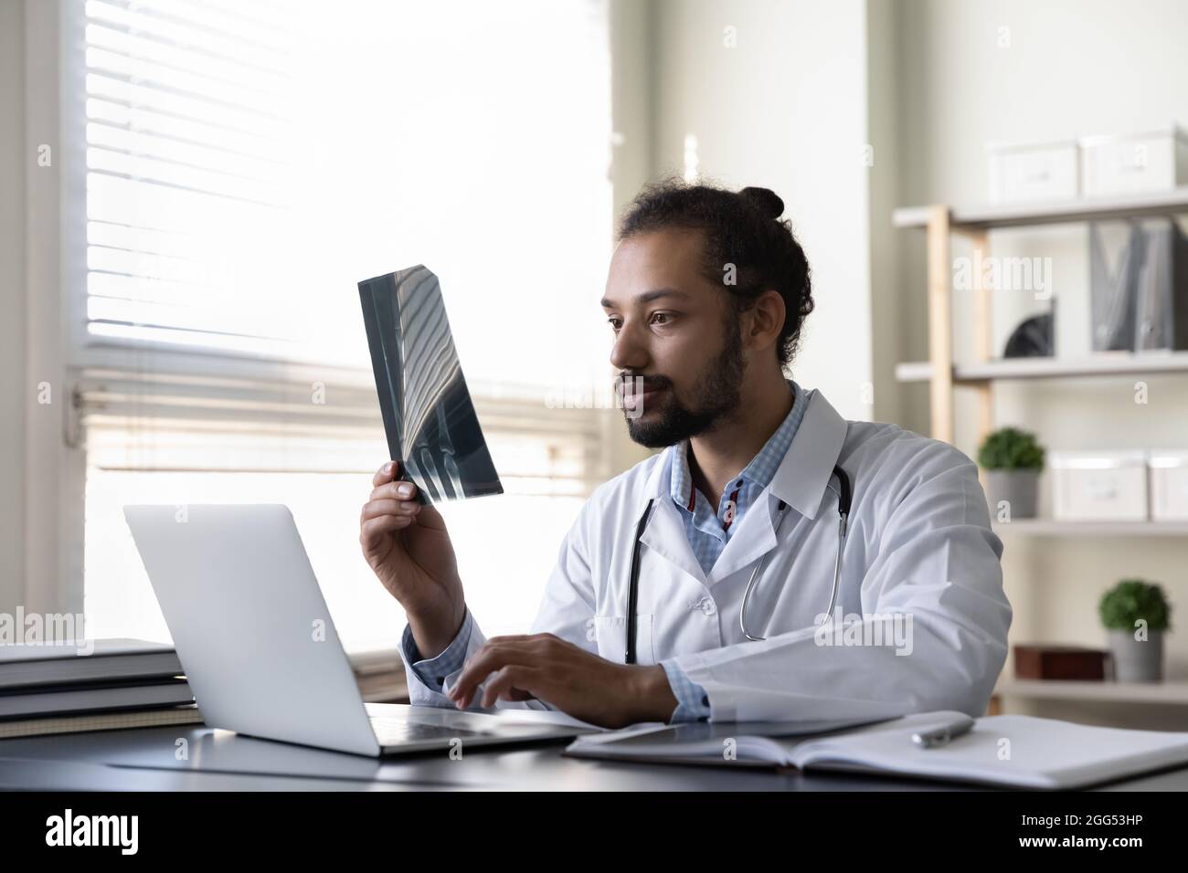 Concentrato giovane traumatologo afro-americano consulente paziente. Foto Stock