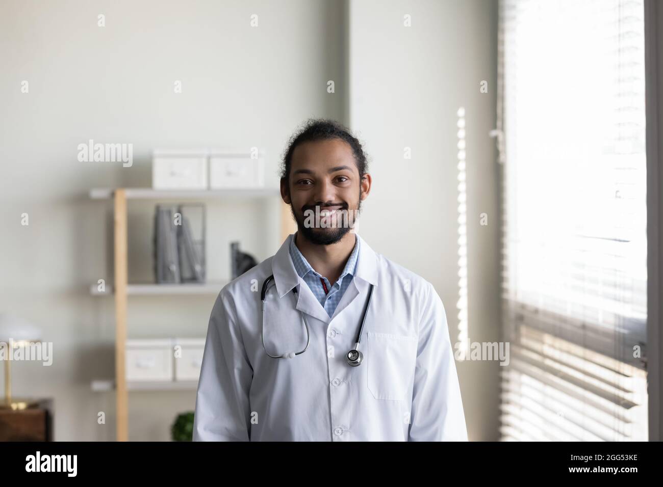 Ritratto di fiducioso sorridente giovane medico africano americano gp. Foto Stock