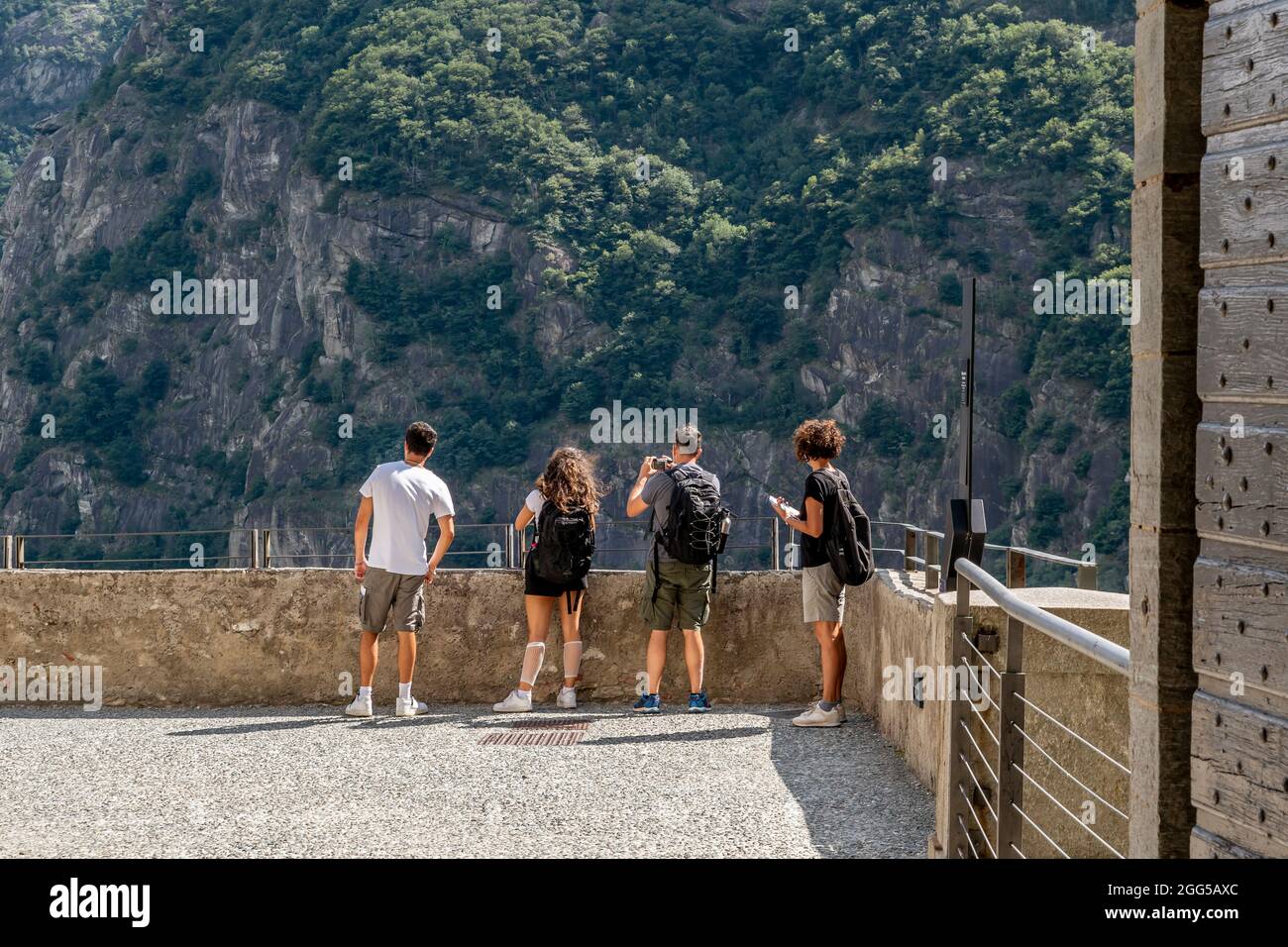Due coppie di turisti si affacciano su una terrazza del Forte di Bard, Italia, per ammirare e fotografare il paesaggio circostante Foto Stock