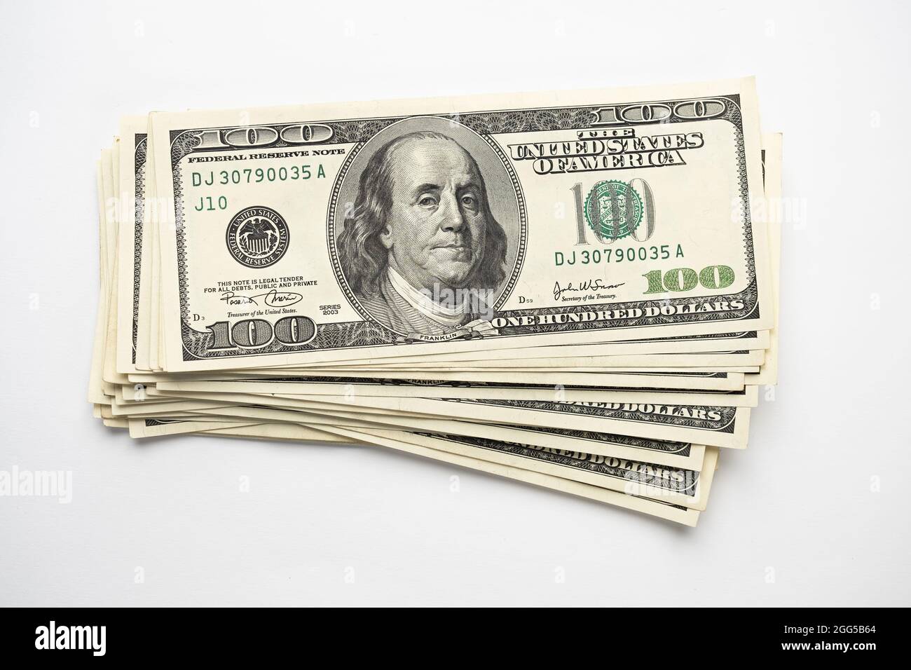 Un mucchio di denaro di cento banconote americane impilate con il ritratto del presidente Franklin su sfondo bianco. Contanti di cento fatture del dollaro, curre di soldi della carta Foto Stock