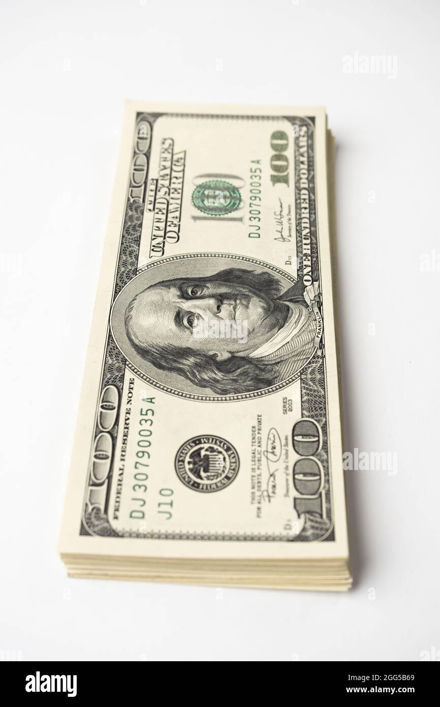 Un mucchio di denaro di cento banconote americane impilate con il ritratto del presidente Franklin su sfondo bianco. Contanti di cento fatture del dollaro, curre di soldi della carta Foto Stock